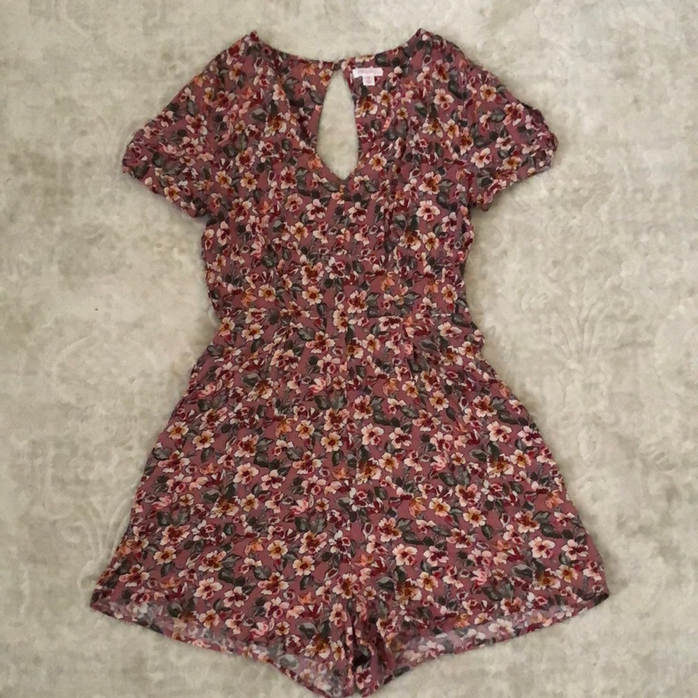 This is a pink floral romper with arm sleeve cut outs and a small back cut out.